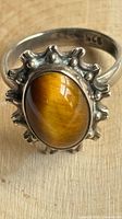 front view of sterling silver ring with oval tiger’s eye stone