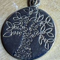Close-up of pendant showing etched Tree of Life design and 925 stamp