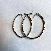 Both twisted silver hoop earrings side by side front view