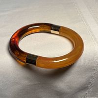 Bracelet angled view showing amber colour gradient and gold-tone end caps