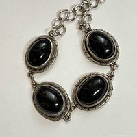 Close-up of four cabochon links showing stone and bezel texture
