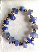 full view of bracelet laid flat showing blue agate beads and silver-tone spacers
