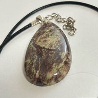 Front view of teardrop jasper pendant on black cord