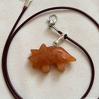 Front view of agate triceratops pendant and burgundy cord