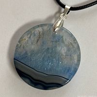Front view of blue druzy agate pendant on cord