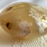Side view of translucent flower agate showing white blossom inclusions