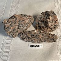 Three granite fragments on cloth background with label