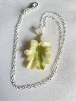 Full view of necklace showing flower pendant and silver chain