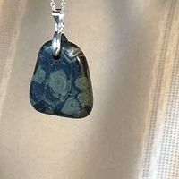 Front view of kambaba jasper pendant suspended from chain