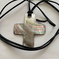 Front view of iridescent shell cross pendant with cord