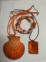 Overview of scallop shell pendant necklace, rectangular shell pendant necklace and stretch bracelet