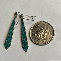Pair of inlay bar earrings beside coin for scale