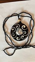 Front view of necklace showing pendant design and seed bead cord