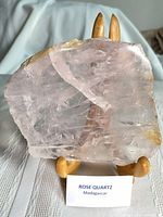 Front view of rose quartz slice on stand with origin label visible