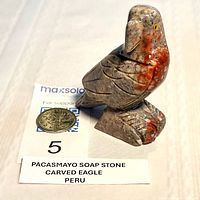 Front view of soapstone eagle with coin for scale