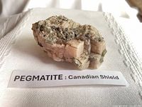 Pegmatite specimen on cloth with label