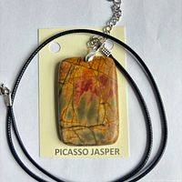 Pendant on backing card showing stone pattern and attached cord