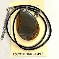Pendant on card with cord coiled, showing overall lot