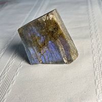 Front view showing iridescent purple and blue flashes on rough labradorite block