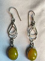 Full view of both earrings showing hooks, teardrop links and yellow cabochons