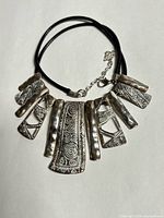 Full view of necklace laid flat showing pendants and cord