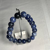 Bracelet displayed upright on stand showing sodalite beads and stretch cord