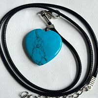 Heart pendant necklace coiled to show full pendant and cord