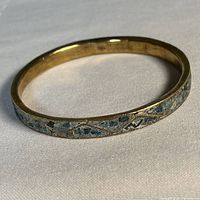 Full view of brass bangle showing turquoise chip inlay