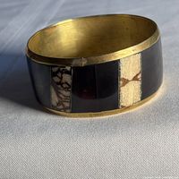 Wide brass bangle showing inlay pattern and brass interior