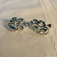 Pair of rhinestone clip-on earrings on fabric background