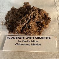 Front view of entire wulfenite with mimetite specimen on display card