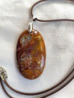front view of oval red agate pendant on cord