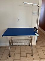 Full view of grooming table with arm and shelf