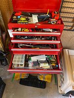 Overview of three open drawers showing full assortment of hand tools and hardware; chest itself visible but not included