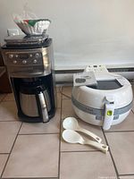 Cuisinart coffee maker, T-Fal Actifry, spoons and manuals grouped together