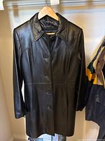 Full front view of black leather coat on hanger