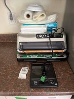 Vacuum sealer, bag rolls, Kirkland bag box, jar sealer, kitchen scale