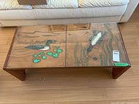 Top view of table showing carved, painted loon scenes under glass and overall form