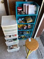 Overall lot showing teal shelf with tools, five-drawer organizer, and stool
