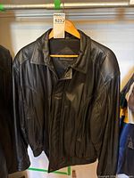 Front view of black leather jacket on hanger