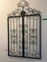 Full view of rectangular wrought iron gate panel hung on wall