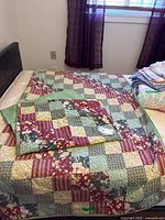 Quilt spread on bed showing patchwork top and folded corner revealing backing