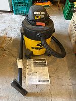 Full view of Shop-Vac with hose, wand, manual visible on floor