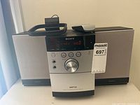 Front view of receiver flanked by two speakers with remote on top