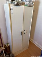 Full view of closed white two-door cabinet showing size and handles