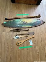 Group shot showing all wooden items: landscape panel, cane, two paddles, figurine