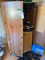 Cabinet front left view, door partly open showing corkboard insert and internal shelves