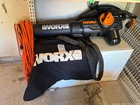 Full view of Worx WG509 TRIVAC tool with collection bag and extension cord