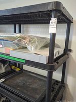 Full view of upper shelves showing black plastic construction and grid shelves