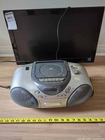 Panasonic boombox in front of Toshiba TV with measuring tape for scale